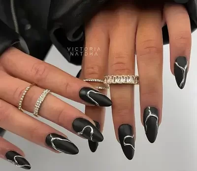 edgy black nail design with silver chrome veining