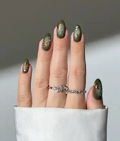 metallic forest leaf nail art design against a green aura base 