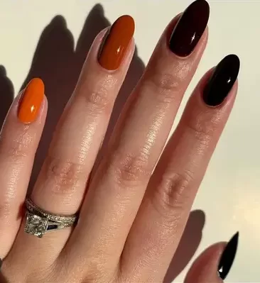 dark fall nail colors from burnt orange to black displayed on woman's manicure
