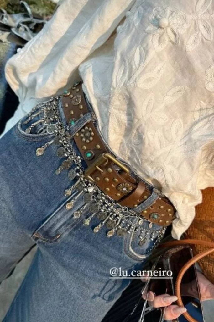 casual fall boho outfit with white flowy top and jeans styled with layered belts