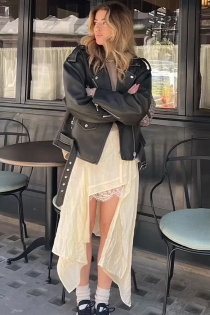 moto boho outfit on young woman wearing flowy lace dress and leather jacket