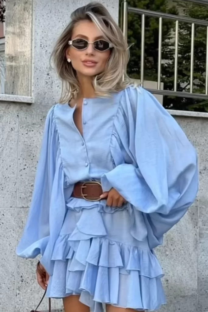 woman in light blue boho dress with long sleeves belted at the waist