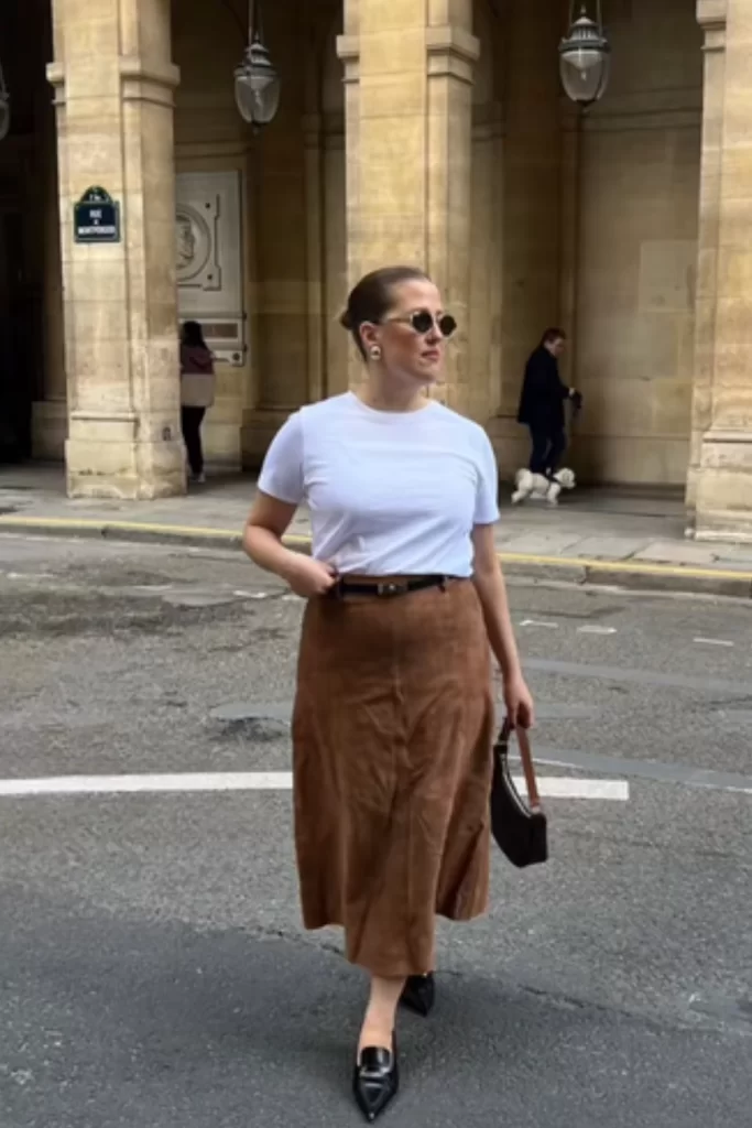 woman wearing simple and casual fall outfit with a brown suede midi skirt and white tee shirt