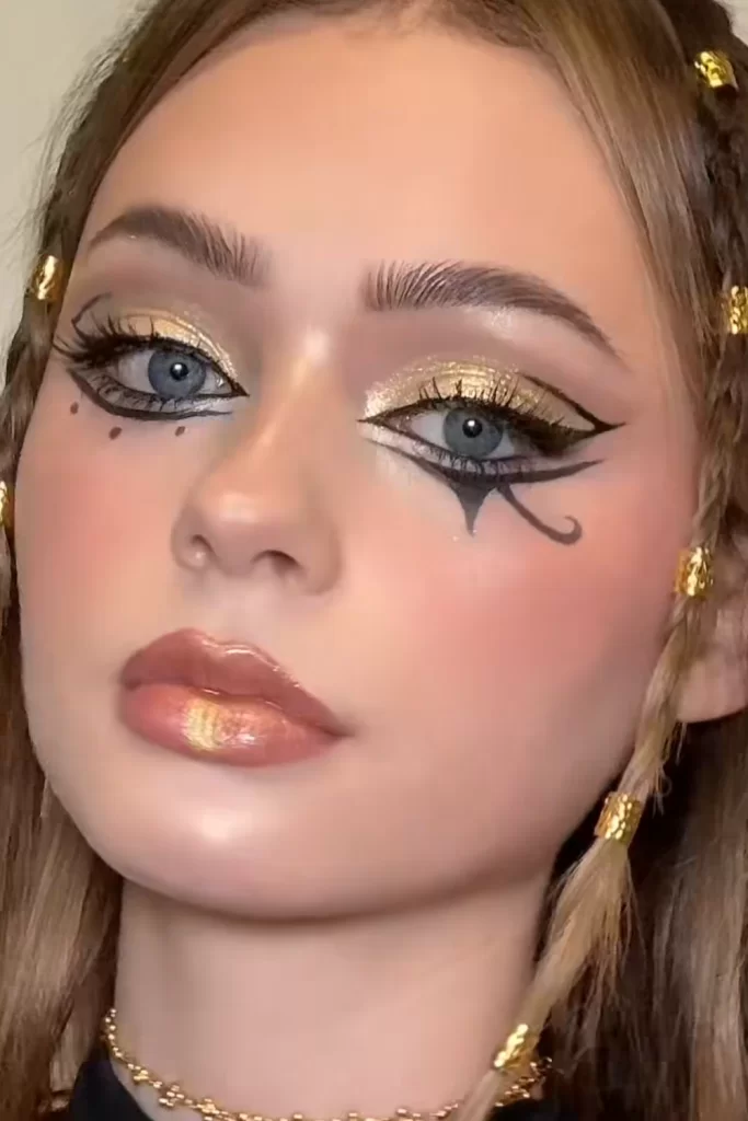 Gold glittery inspired Cleopatra Halloween makeup inspiration on young blonde woman