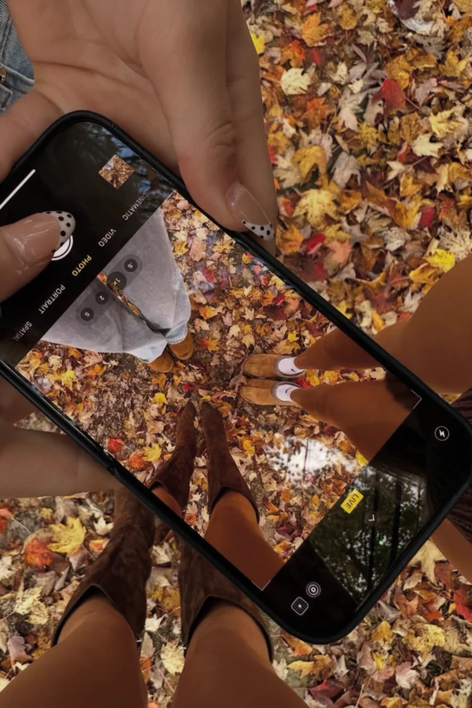 Trendy overheard Fall aesthetic photo showing three girls posing against leaves