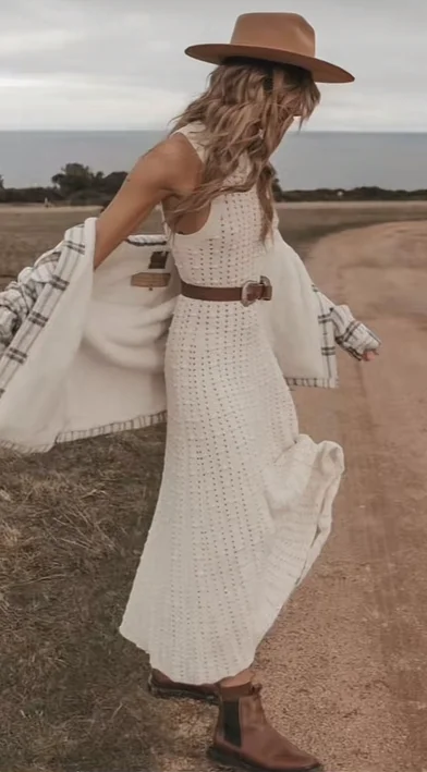 Model wearing pointelle sweater dress with belt and sherpa lined jacket