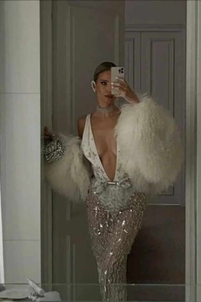 Glamorous sheer white winter outfit on woman wearing oversized feather like coat